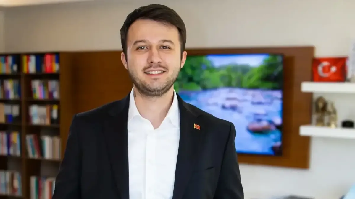 Lavanta yağı şişesi ve mor lavanta çiçekleri masada duruyor.